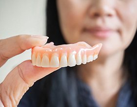 Woman holding dentures