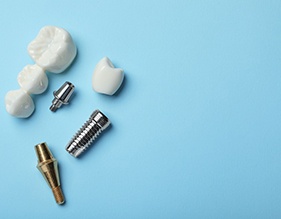 The parts of dental implants and bridges against a blue background