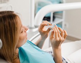 Patient holding clear aligner in treatment room