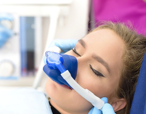 Young woman breathing in nitrous oxide through nasal mask