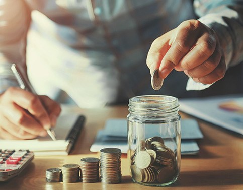 Someone putting coins into a jar