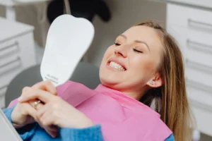  Female patient looking in dental mirror