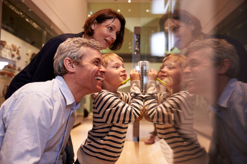 Dentures patient smiling with family at a museum 