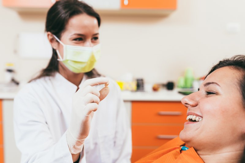 A dentist holding a patient’s extracted tooth